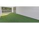 Side view of a covered patio with artificial turf and white siding at 695 Old Peachtree Rd, Lawrenceville, GA 30043