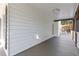 Side porch with white vertical siding, dark trim, and tongue and groove porch flooring at 695 Old Peachtree Rd, Lawrenceville, GA 30043