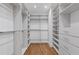 Bright walk-in closet showcasing hardwood floors and custom shelving and drawers at 695 Old Peachtree Rd, Lawrenceville, GA 30043