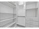 Bright, white walk-in closet featuring custom shelving and drawers to keep you organized at 695 Old Peachtree Rd, Lawrenceville, GA 30043