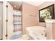 A bathtub and shower with blue and white curtains are featured in this bathroom with a large framed picture at 710 Josh Ln, Lawrenceville, GA 30045