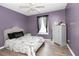This bedroom features gray wood-look flooring, purple walls, white trim, and a window with black curtains at 710 Josh Ln, Lawrenceville, GA 30045