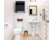 Cozy half bathroom with pedestal sink, black cabinet, and stylish mirror at 710 Josh Ln, Lawrenceville, GA 30045