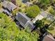 Aerial view of the backyard with mature trees, a patio, and the home's dark roof at 745 Princeton Mill Run, Marietta, GA 30068