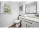 Contemporary bathroom with a white vanity, framed mirror, and wood-look flooring, filled with natural light at 745 Princeton Mill Run, Marietta, GA 30068