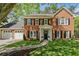 Two-story brick home features a manicured lawn, white trim, and a two-car garage, creating classic curb appeal at 745 Princeton Mill Run, Marietta, GA 30068