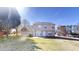View of a spacious, grassy backyard with a two-story home and blue skies at 921 Dunagan Way, Lawrenceville, GA 30045