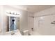 Bright bathroom featuring a white tiled shower/tub and square mirror over a white vanity at 921 Dunagan Way, Lawrenceville, GA 30045