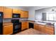 Functional kitchen featuring wood cabinetry, black appliances, and a convenient layout for cooking and entertaining at 2877 Deerwood Sw Dr, Atlanta, GA 30331