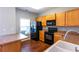 Modern kitchen with wood cabinets, sleek black appliances, and an adjacent dining area, perfect for Gathering meals at 2877 Deerwood Sw Dr, Atlanta, GA 30331