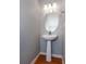 Cozy powder room features a classic pedestal sink and modern lighting for a fresh, clean look at 2877 Deerwood Sw Dr, Atlanta, GA 30331