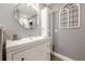 Bathroom featuring gray walls, white vanity with sink, a modern mirror, and a decorative window at 3201 Lenox Ne Rd # 16, Atlanta, GA 30324