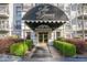 Building entrance marquee with gold-trimmed doors framed by green hedges and manicured landscaping at 3201 Lenox Ne Rd # 16, Atlanta, GA 30324