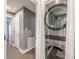 Modern, stainless steel stacked washer and dryer unit in laundry room with neutral walls and gray tiled floor at 3201 Lenox Ne Rd # 16, Atlanta, GA 30324