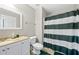 Bathroom with a white vanity, sink, and walk-in shower with green and white striped curtain at 100 Annes Ln, Sharpsburg, GA 30277