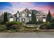 Elegant two-story home with a stone water feature, manicured landscaping, and a combination of brick and siding at 100 Annes Ln, Sharpsburg, GA 30277