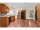 Spacious kitchen with wood cabinets, tile backsplash, stainless steel appliances, and hardwood floors at 100 Annes Ln, Sharpsburg, GA 30277
