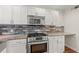 Modern kitchen features stainless steel appliances, stylish tile backsplash, granite countertops, and white cabinets at 1261 Lavista Ne Rd # M-4, Atlanta, GA 30324
