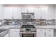 Updated kitchen featuring stainless steel appliances, granite counters, and white cabinetry at 1261 Lavista Ne Rd # M-4, Atlanta, GA 30324
