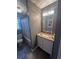 A cozy bathroom featuring a granite countertop vanity, patterned shower curtain, and elegant lighting at 7503 E Cherokee Dr, Canton, GA 30115