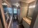 A narrow bathroom features a granite countertop vanity, patterned shower curtain, and decorative lighting at 7503 E Cherokee Dr, Canton, GA 30115