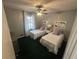 Inviting bedroom featuring two twin beds with matching decor, carpet floor, and a decorative ceiling fan at 7503 E Cherokee Dr, Canton, GA 30115