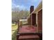 View of a brick patio with wooden rails, part of a red brick home with a chimney at 3153 Lake Monroe Rd, Douglasville, GA 30135