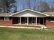 Charming brick ranch-style home with black shutters and a welcoming covered front porch at 3153 Lake Monroe Rd, Douglasville, GA 30135