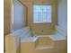 A soaking tub sits beneath a window in this bright bathroom at 440 Cottonpatch Rd, Lawrenceville, GA 30046