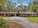 Red brick house with attached carport and circular driveway surrounded by mature trees at 738 Lauren Cir, Lawrenceville, GA 30043
