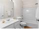 Well-lit bathroom with a combination tub and shower, featuring white tile surround at 1555 Diplomat Dr, Cumming, GA 30041