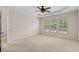 Bright bedroom with neutral carpet, tray ceiling, and large shuttered windows for ample natural light at 1555 Diplomat Dr, Cumming, GA 30041