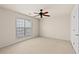 This is a carpeted bedroom with a window and a ceiling fan with wood blades at 1555 Diplomat Dr, Cumming, GA 30041