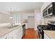 Kitchen with stainless steel appliances, white cabinets, and hardwood flooring at 1555 Diplomat Dr, Cumming, GA 30041