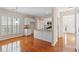 Spacious kitchen with hardwood floors, white cabinetry, and an eat-in bar provides casual dining at 1555 Diplomat Dr, Cumming, GA 30041