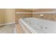 Bathroom featuring tile accents surrounding a jetted tub, faucet fixtures, and tile flooring at 7438 Chilton Ln, Riverdale, GA 30296