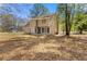 View of a two-story house surrounded by trees and natural landscape at 7438 Chilton Ln, Riverdale, GA 30296