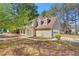 Tan two-story home featuring a well-maintained lawn and two dormer windows at 7438 Chilton Ln, Riverdale, GA 30296