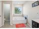 Bathroom with a soaking tub, a window, a tiled backsplash, and tiled floors at 4050 Ironwood Dr, Atlanta, GA 30349