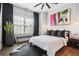 Modern bedroom with hardwood floors, a ceiling fan, a large window, and decorative wall art at 605 Broadview Ne Pl, Atlanta, GA 30324