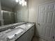 Well-lit bathroom with double sink vanity, granite countertop, and a shower featuring a glass door at 950 Spring Ives Dr, Lawrenceville, GA 30043