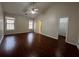 Spacious bedroom featuring a ceiling fan, hardwood floors, two windows, and an ensuite bathroom with a walk-in closet at 950 Spring Ives Dr, Lawrenceville, GA 30043