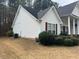 Side view of a home with white siding and manicured bushes in the front yard at 950 Spring Ives Dr, Lawrenceville, GA 30043
