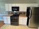 Well-equipped kitchen with black appliances, white cabinetry, and tan countertops at 108 Creekwood Trl, Acworth, GA 30102