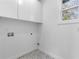 Bright laundry area with tile flooring and white cabinets at 1247 Bridges Sw Ave # A, Atlanta, GA 30310