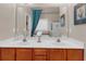 Bathroom featuring double sink vanity with white countertop and framed mirror at 3919 Teal Cir, Powder Springs, GA 30127