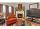 Bright living room featuring a fireplace, hardwood floors and a cozy, orange chair at 3919 Teal Cir, Powder Springs, GA 30127