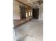 Unfinished living room showing open layout, exposed ceiling, and a brick half wall at 8947 Yarmouth Dr, Jonesboro, GA 30238