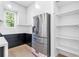 Close-up of kitchen featuring stainless steel refrigerator, white cabinets, and open shelving at 1247 Bridges Sw Ave # B, Atlanta, GA 30310