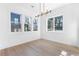 Bright living room with hardwood floors, a contemporary light fixture, and natural light from three windows at 1247 Bridges Sw Ave # B, Atlanta, GA 30310